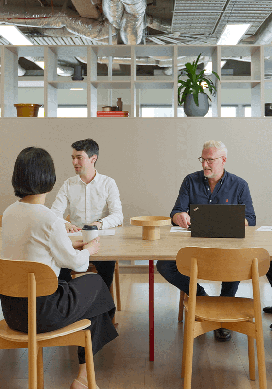 Macroplan colleagues discussing a project around a table